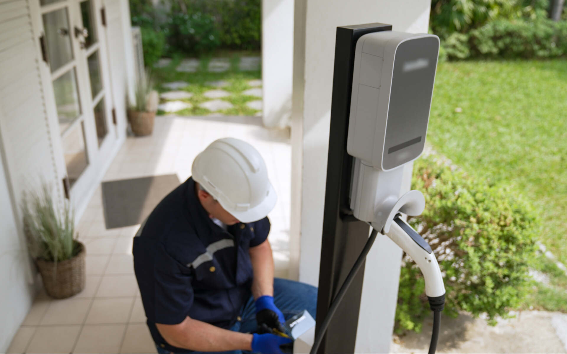 Technician completing EV charger installation outside a residential home.