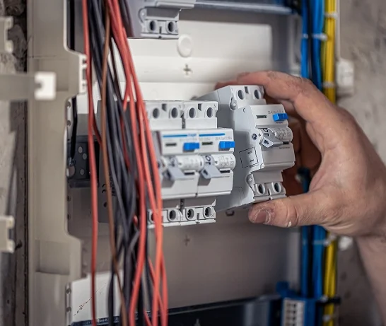 male-electrician-works-switchboard-with-electrical-connecting-cable